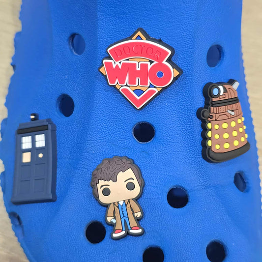 Blue shoe with Doctor Who-themed pins including TARDIS, Dalek, and character on a light brown background