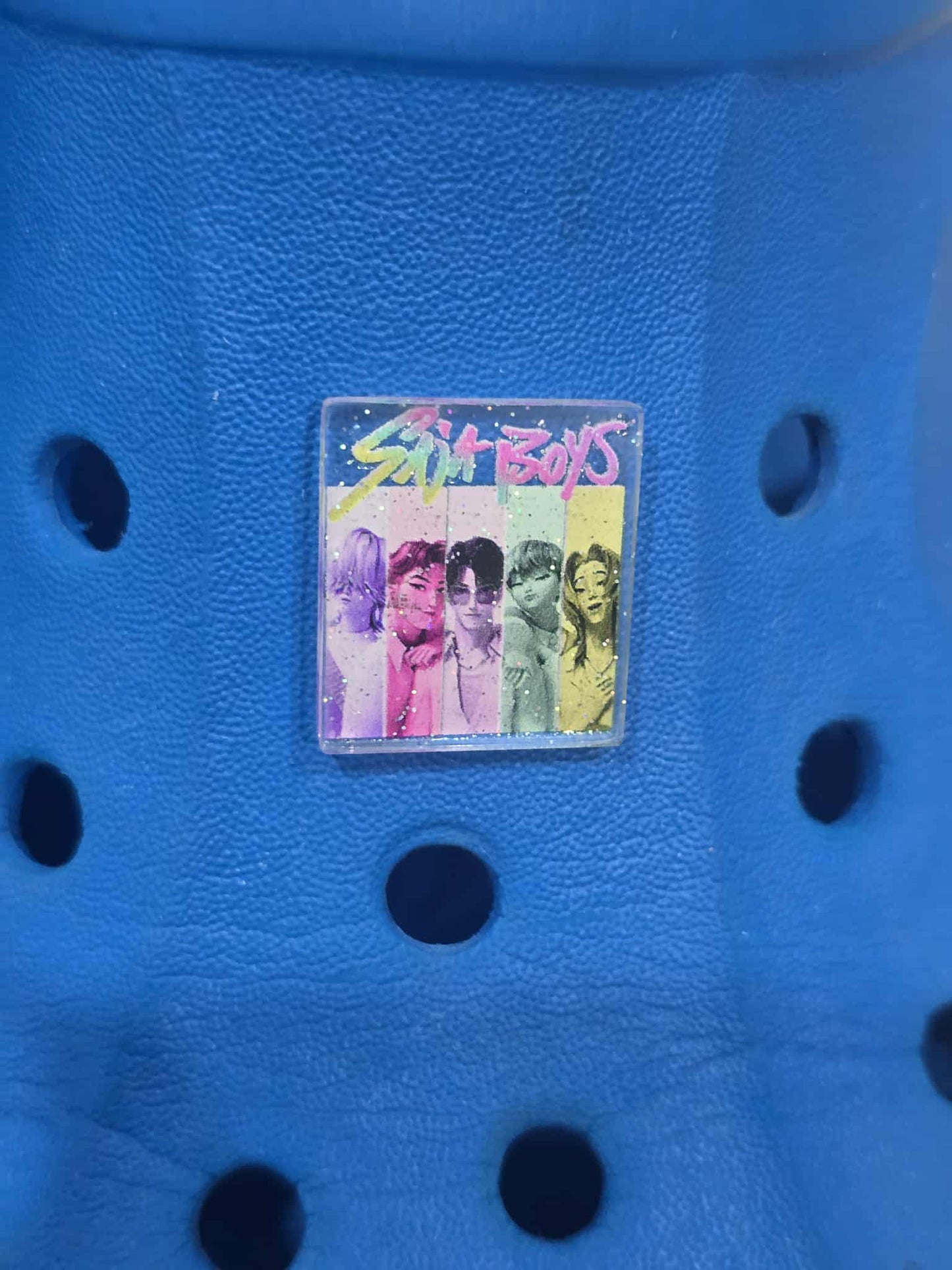 Small square sticker with colorful design on a blue textured surface