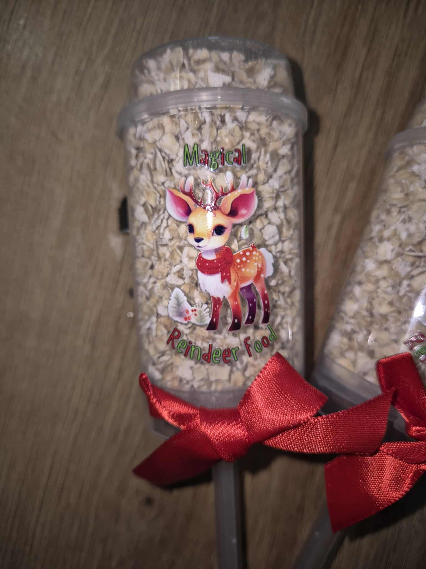 Jar of 'Magical Reindeer Tea' with a reindeer illustration and red ribbon on a wooden surface.