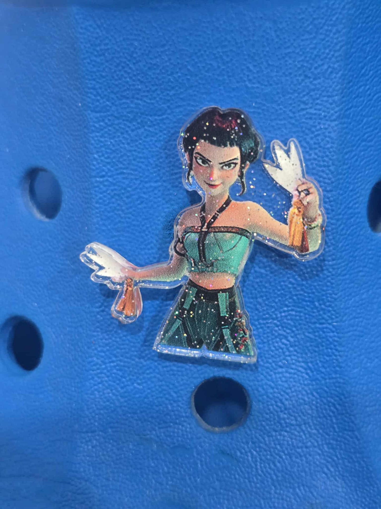 Transparent figurine of a character with green dress on a blue textured background