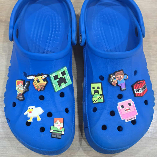 Blue clogs with Minecraft-themed charms on a wooden surface