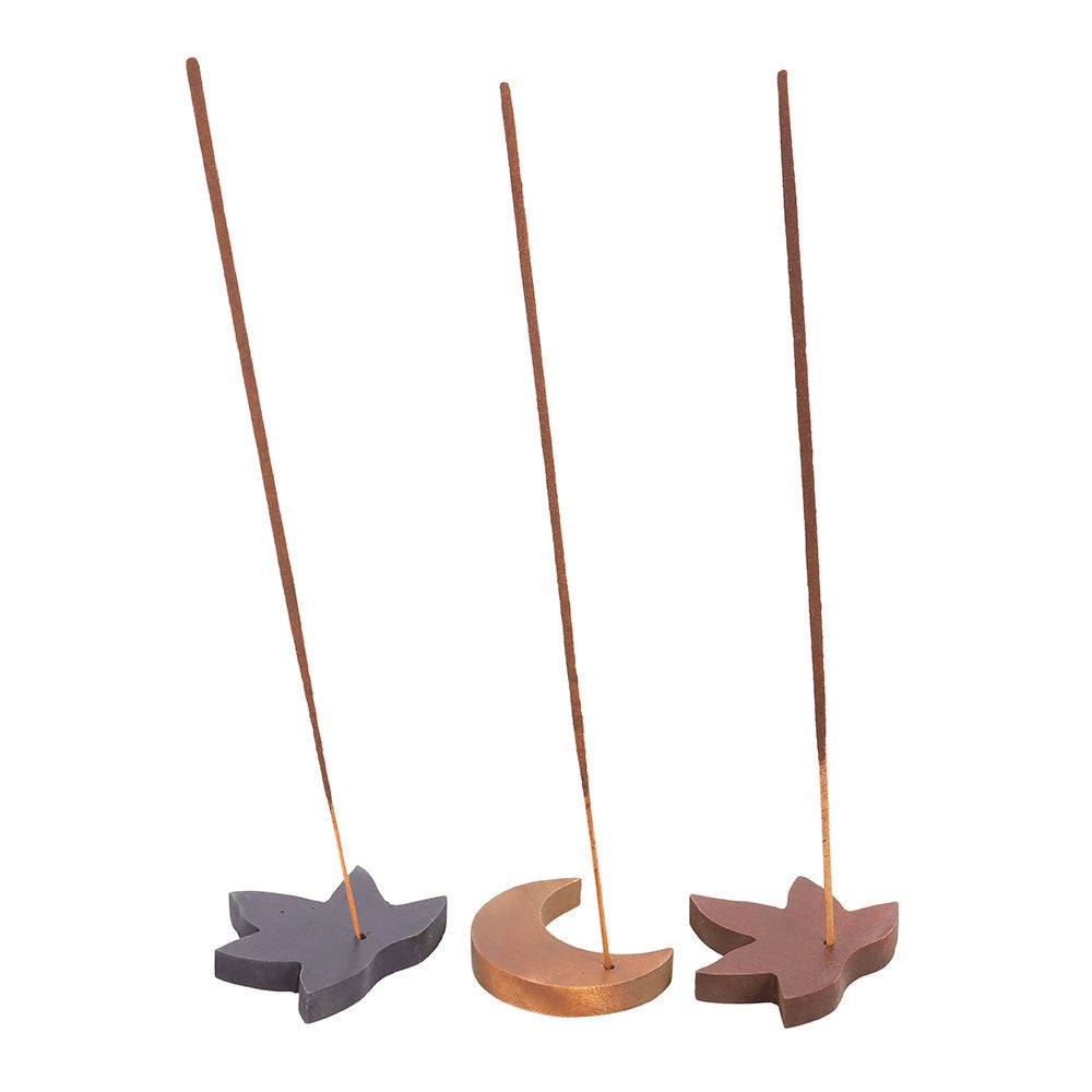 Three wooden incense holders shaped like a fish, moon, and leaf on a white background