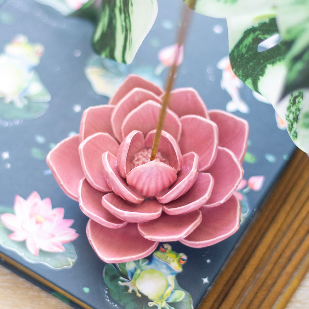 Pink ceramic lotus flower on a decorative box with floral patterns