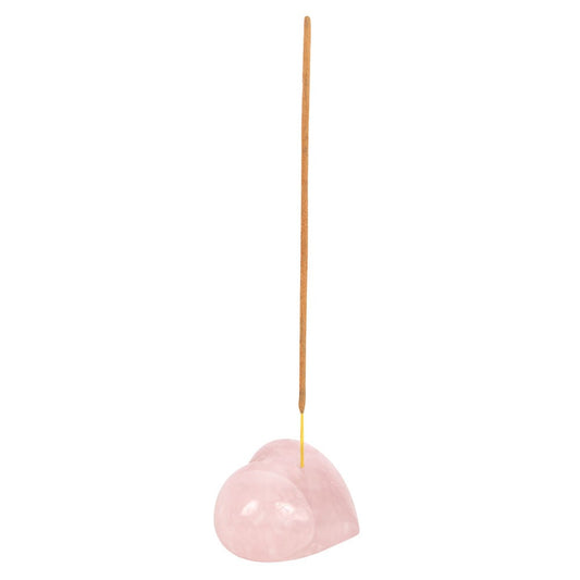 Heart-shaped pink incense holder with a single incense stick on a white background